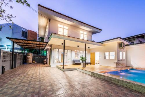 a home with a swimming pool and a house at Coco59- Private 3BR Pool Villa in Bangkok