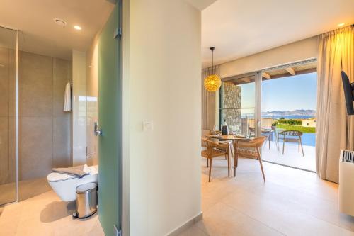 a modern bathroom with a view of the dining room and living room at Casa Tierra - Villa II in Kos