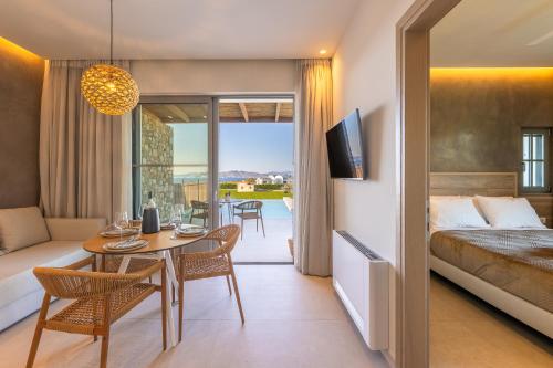 a hotel room with a bed and a table and chairs at Casa Tierra - Villa II in Kos