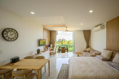 a living room with a table and a clock on the wall at Beach Studio in Ấp Phú Tịnh (2)