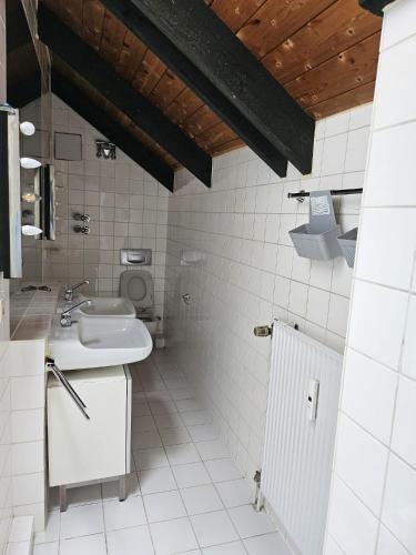 a white bathroom with a sink and a toilet at Paradies 1 in Bonn