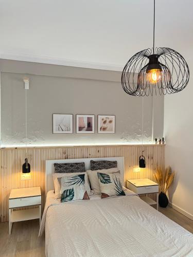 a bedroom with a large bed with two tables at Quarto confortável com varanda in Amadora