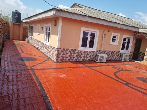 a house with a red tiled driveway in front of it at Luxury & Secured 3 Bedroom House with 24 Hours Solar Light in Ikorodu