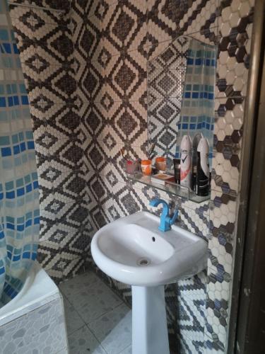 a bathroom with a white sink and a shower at Luxury & Secured 3 Bedroom House with 24 Hours Solar Light in Ikorodu