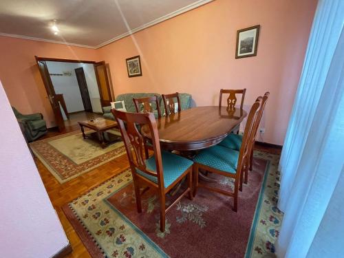 a dining room with a wooden table and chairs at Apartamento El Llerau Cangas de Onis in Cangas de Onís