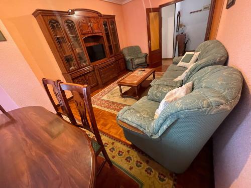 a living room with a bed and a table and chairs at Apartamento El Llerau Cangas de Onis in Cangas de Onís