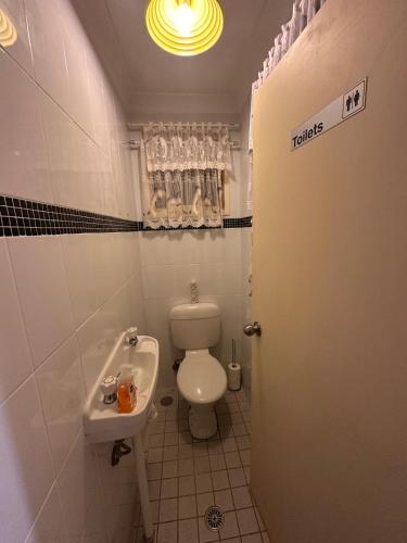 a small bathroom with a toilet and a sink at Peaceful Queen Room in Cozy Garden House - KV4 in Kellyville