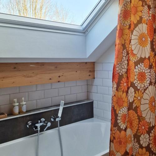 a bathroom with a bath tub with a shower curtain at Paulette à bicyclette in Méry