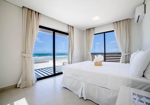 a bedroom with a bed and a view of the ocean at The Coral Beach Resort in Trairi