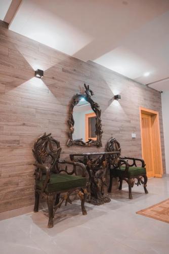 a mirror on a wall with a table and benches at The Garden Hotel in Islamabad