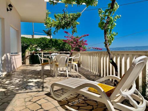 a patio with chairs and a table with a view of the ocean at Vacation home ĆaĆa in Jesenice
