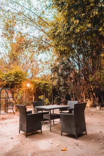 a picnic table with four chairs around it at The Garden Hotel in Islamabad