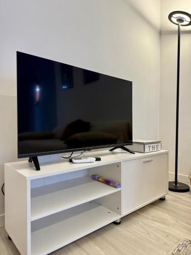 a white entertainment center with a flat screen tv on it at LR Deluxe Apartments - Casa Holi in Pero