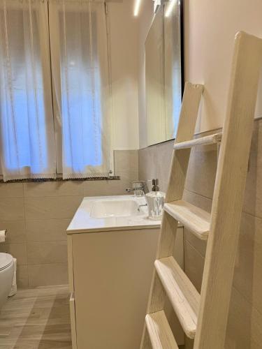 a bathroom with a sink and a toilet and a mirror at LR Deluxe Apartments - Casa Holi in Pero