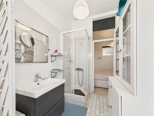 une salle de bain blanche avec un lavabo et une douche dans l'établissement Maison pour 4 avec terrasse proche du centre, à Les Sables-dʼOlonne