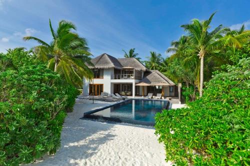 an exterior view of a villa with a swimming pool at Dusit Thani Maldives - 50 percent discount on transfers for stays until 20 Dec 2025 in Baa Atoll