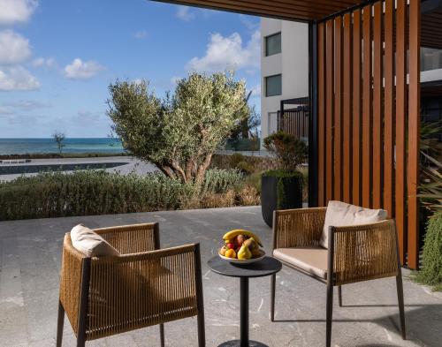 two chairs and a table with a bowl of fruit at Idou Malabata Beach and SPA in Tangier