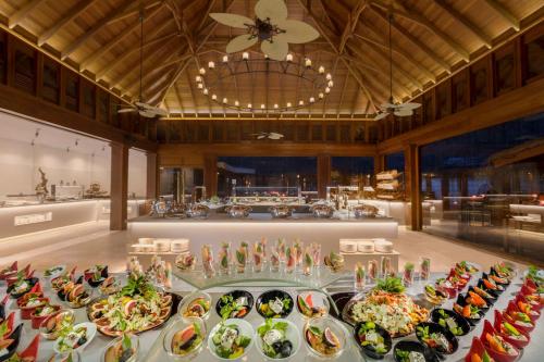a table filled with plates of food in a room at Dusit Thani Maldives - 50 percent discount on transfers for stays until 20 Dec 2025 in Baa Atoll
