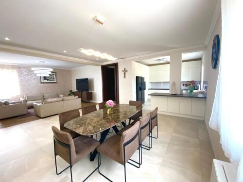 a dining room and living room with a table and chairs at Penthouse Olivia Međugorje - Private Jacuzzi in Međugorje