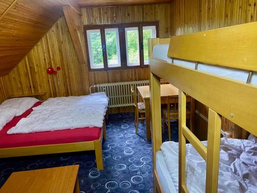 a small room with two beds and a table and a desk at Chata v Krkonoších, 6 rooms, 25 beds in Vítkovice