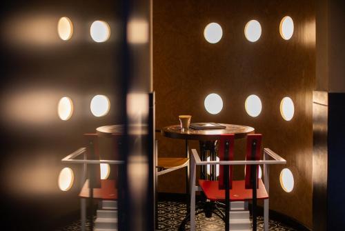 a room with a table and two red chairs at SIXI CANGSHAN MOUNTAINS GOLDEN SUNRISE MIRROR OF THE SKY SOUND SLEEP HOTEL DALI ANCIENT CITy in Dali