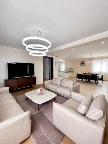 a living room with white furniture and a flat screen tv at Penthouse Olivia Međugorje - Private Jacuzzi in Međugorje