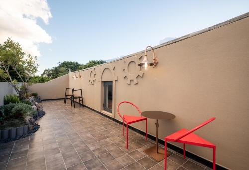 a patio with red chairs and a table on a building at SIXI CANGSHAN MOUNTAINS GOLDEN SUNRISE MIRROR OF THE SKY SOUND SLEEP HOTEL DALI ANCIENT CITy in Dali
