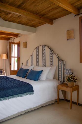 a bedroom with a large white bed with blue pillows at Nomad Hotel & Spa Altea in Altea