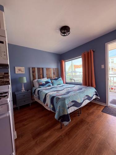 a bedroom with a bed with blue walls and a window at Twilight Motel in Wildwood
