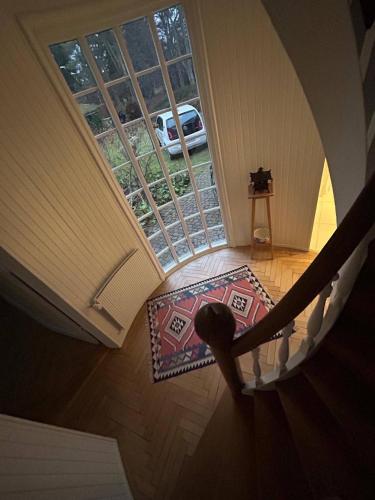 a spiral stairway with a window and a rug at Copenhagen Denmark by the Sea Villa Solrd Strand in Solrød Strand