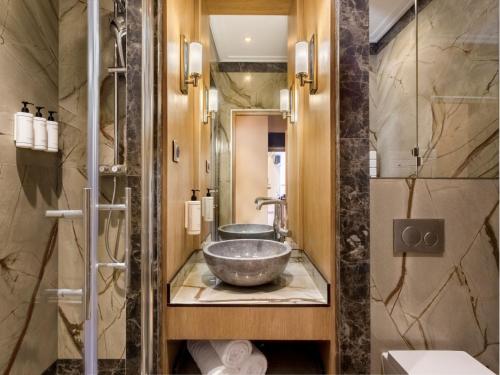 La salle de bains est pourvue d'un lavabo et d'une douche. dans l'établissement Merveil - Signature Suite - Tour Eiffel - Desaix I, à Paris
