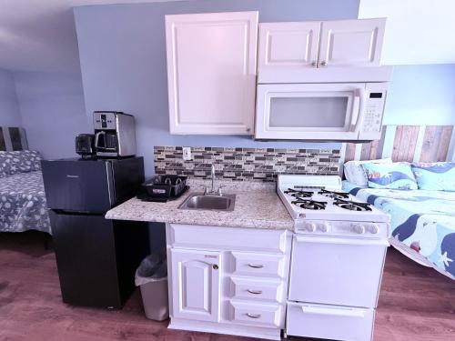 a kitchen with a sink and a microwave and a refrigerator at Twilight Motel in Wildwood