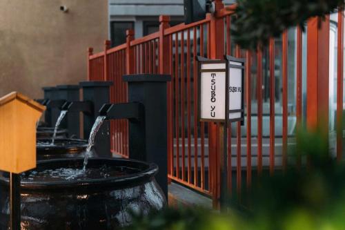 a water fountain with a sign in front of a fence at Vườn Tùng RiverSide retreat & Villa - KDT ECOPARK in Kim Quan