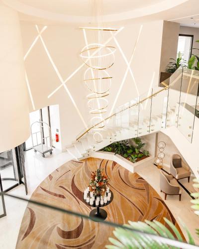 a lobby with a spiral staircase and a table at Villa Misk Alkhobar in Al Khobar