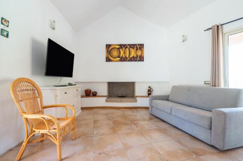 a living room with a couch and a tv at Harmònia Residence in Villasimius