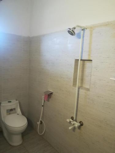a bathroom with a toilet and a shower at Saya Hostel and Hotel in Karachi