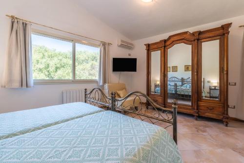 a bedroom with a bed and a large window at Harmònia Residence in Villasimius