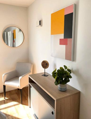 une chaise et une table dans une pièce avec un miroir dans l'établissement Zenao Appart'hôtels Orléans, à Orléans