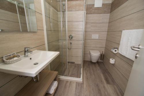 
a bathroom with a toilet, sink, and mirror at Hostel Sol in Dubrovnik
