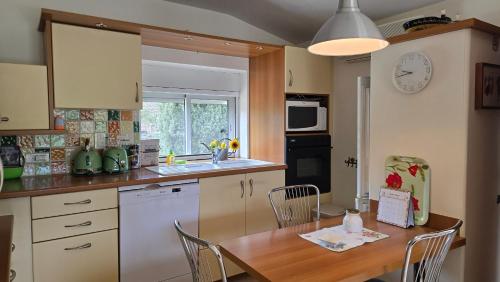 une cuisine avec une table en bois et une salle à manger dans l'établissement Maisonnette avec jardin en campagne, à Montségur-sur-Lauzon