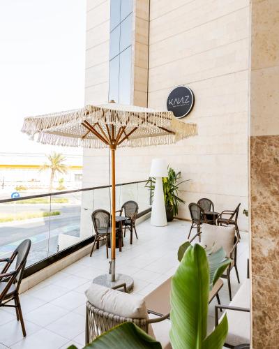 a patio with a table and chairs and an umbrella at Villa Misk Alkhobar in Al Khobar