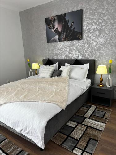 a bedroom with a large bed with a picture on the wall at Muller Residence in Timişoara
