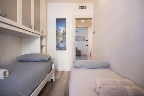 a bedroom with two beds and a hallway at Ava home - apartment in the center Camonica Valley in Boario Terme