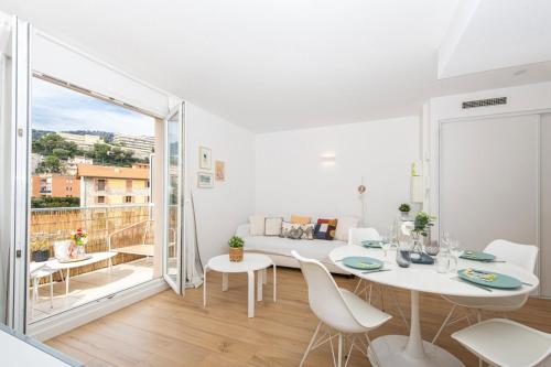 un salon blanc avec une table et des chaises dans l'établissement Jardin du cap, à Roquebrune-Cap-Martin