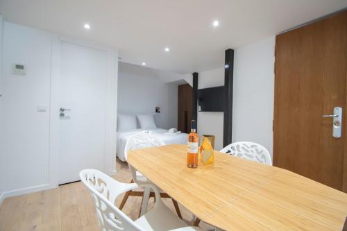 - une bouteille de vin assise sur une table en bois dans la chambre dans l'établissement CIA - Flat in Bonne Nouvelle, 4P, à Paris