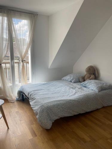 a bedroom with a bed with a teddy bear on it at Amboise centre ville in Amboise