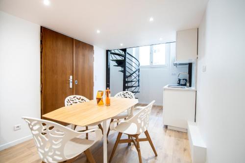 une cuisine et une salle à manger avec une table et des chaises en bois dans l'établissement CIA - Flat in Bonne Nouvelle, 4P, à Paris