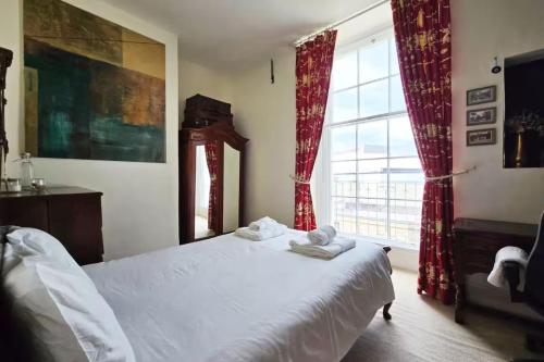Un dormitorio con una cama y una ventana grande. en Classic Georgian Rooms in Centre, en Bath