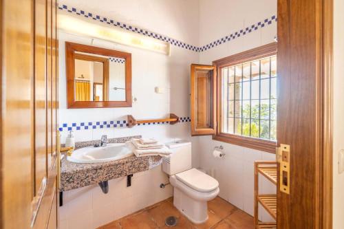 a bathroom with a sink and a toilet and a window at Casa Chica by Rosas Cantares in Pizarra