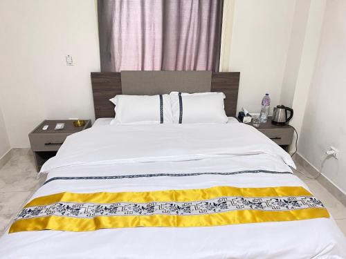 a bedroom with a large bed with a yellow and white blanket at 北京之夜华人民宿餐厅 chinese hotel in Banī Ghālib